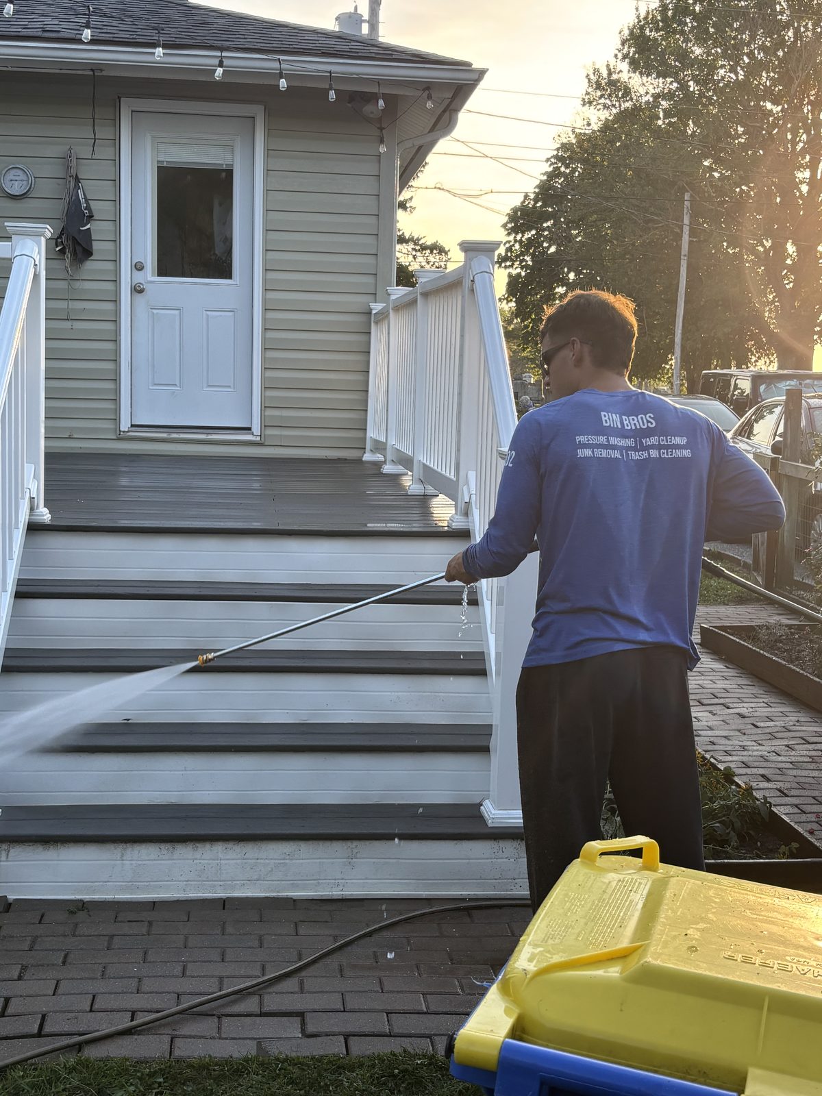 302 Bin Bros technician power washing deck stairs at a Milford Delaware home